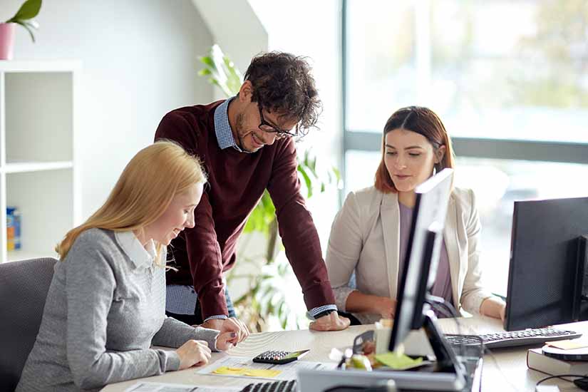 happy business team with calculator at office